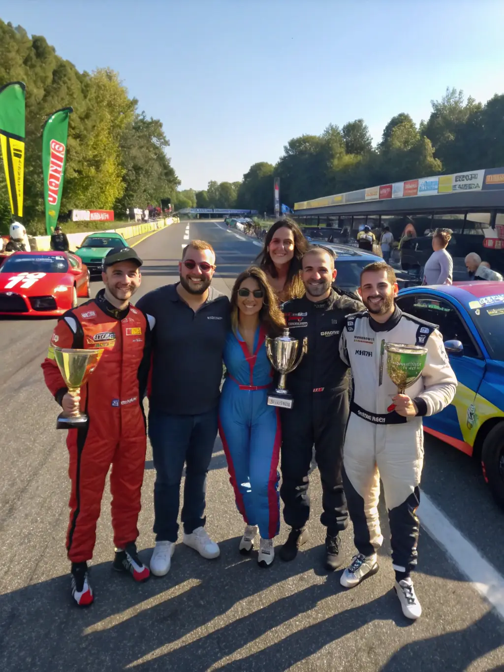 A group photo of ECURIE VESUBIENNE AUTOMOBILE members celebrating a successful race event, capturing the camaraderie and team spirit within the club.